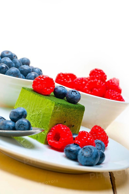 Green tea matcha mousse cake with raspberries and blueberries on top