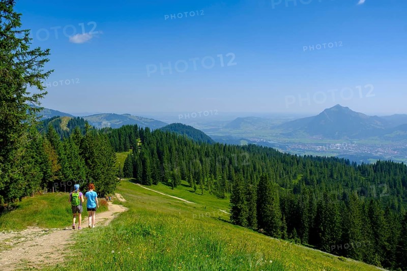 Hikers descending from the Weiherkopf peak near Bolsterlang