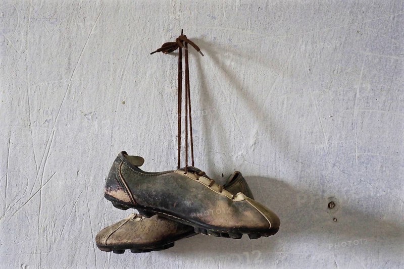 Pair of football shoes hanging on nail