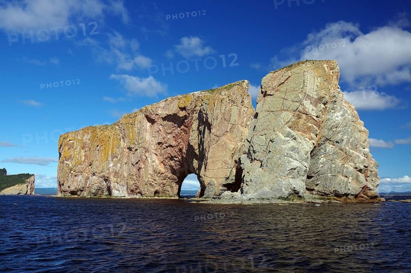 Large rock with gate stands in the sea