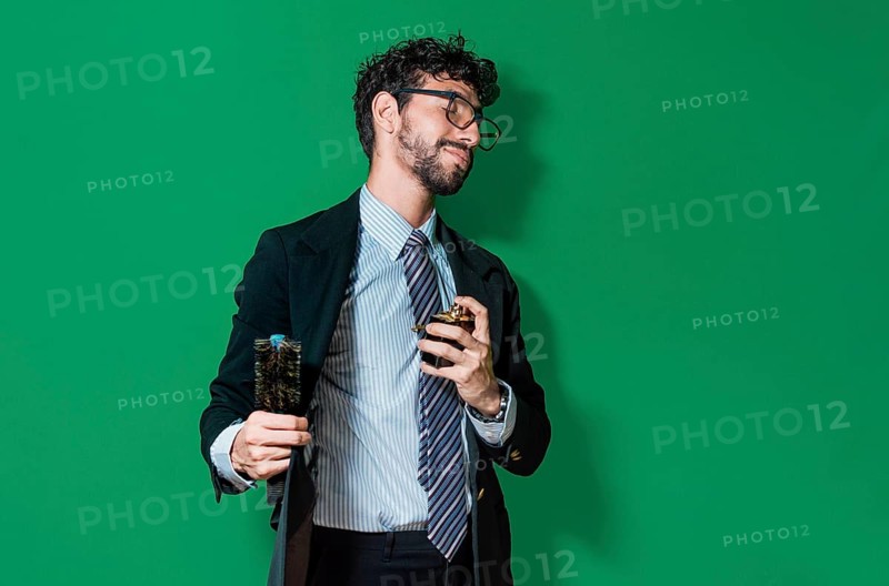 Elegant businessman perfuming himself and combing his hair