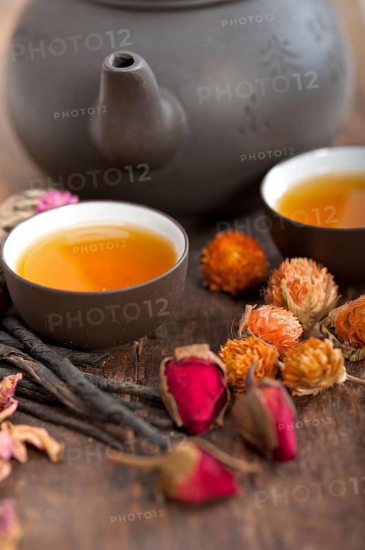 Chinese style herbal floral tea over wood table with raw ingredients
