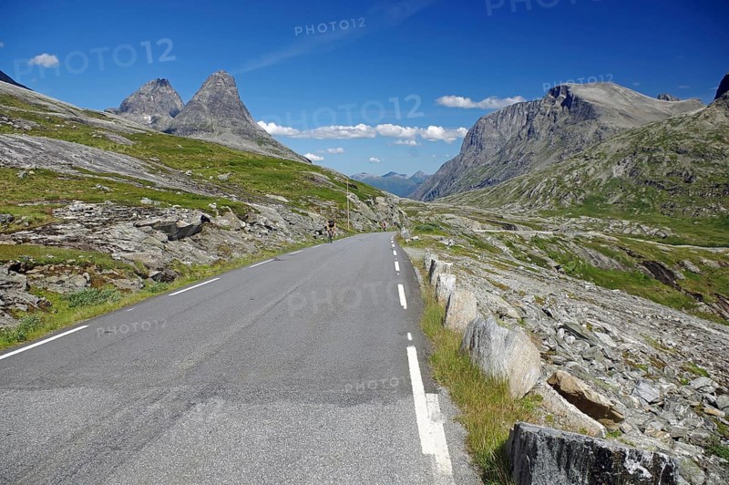Narrow road leads through barren mountain landscape