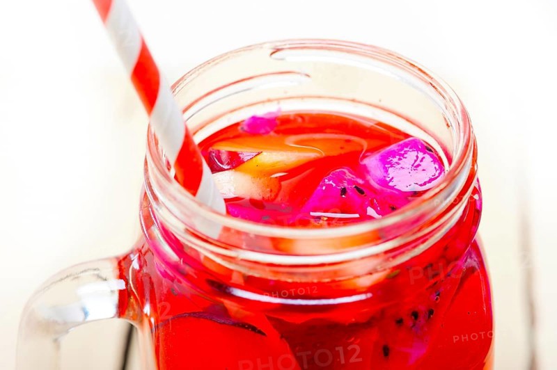 Fresh fruit punch refreshing summer drink over white rustic wood table