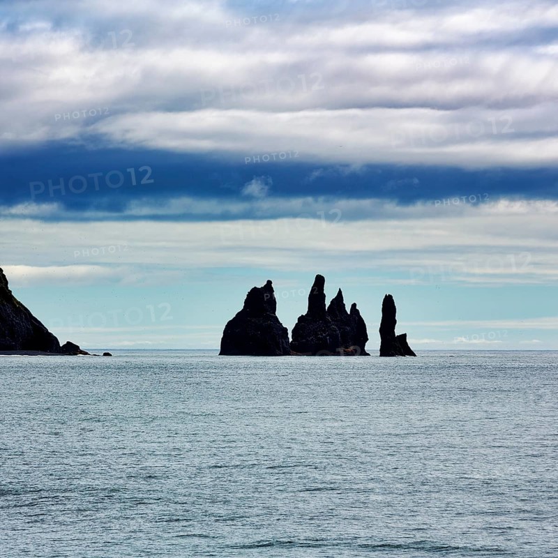 Cloudy sky above rock needles Reynisdrangar in summer