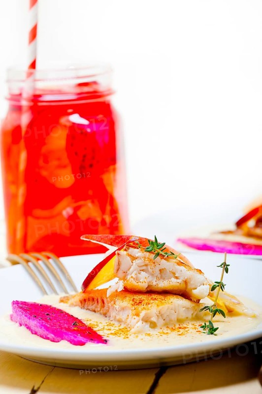 Sea bream orata fillet butter pan fried with fresh peach prune and dragonfruit slices thyme on top