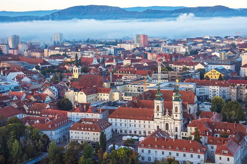 Cityscape of Graz with Mur river and Mariahilfer church