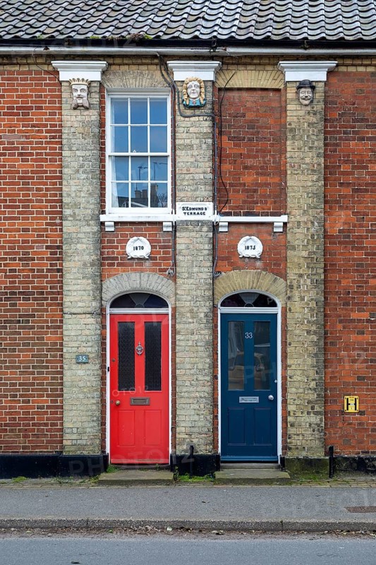Doors of two Victorian red brick houses next to each other
