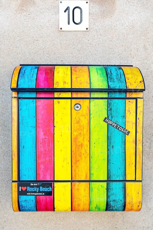 Private letterbox with coloured stripes on a house wall