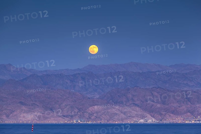 Afull moon over the desert of Akaba in Jordan as seen from the shores of Eilat