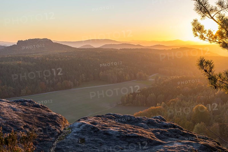 Rocks and vantage point on Pfaffenstein with view of Table Mountain Gohrisch at sunrise