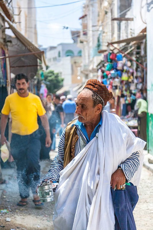An elderly Berber in traditional clothes with incense