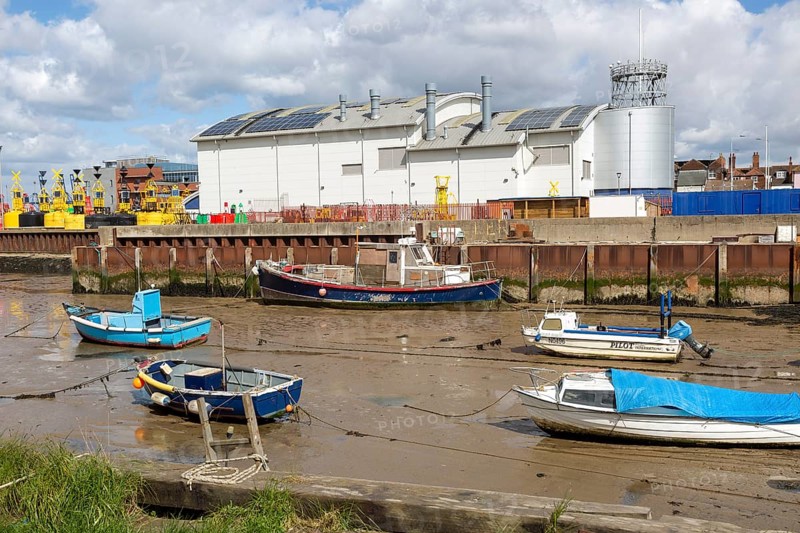 Boats at low tide in muddy creek by Trinity House