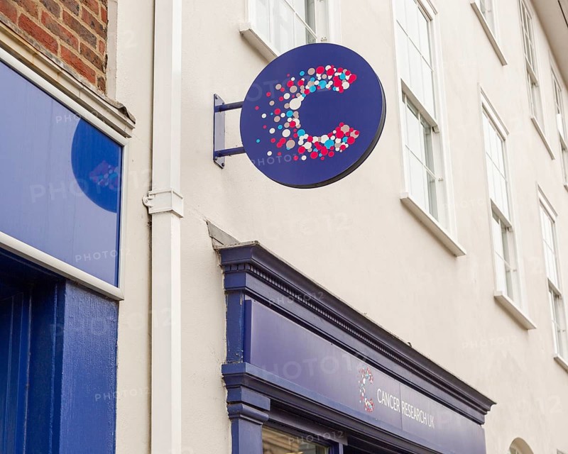 Cancer Research charity shop signs outside High Street store