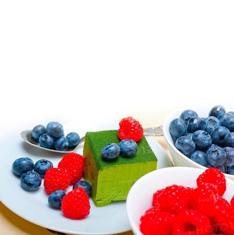 Green tea matcha mousse cake with raspberries and blueberries on top