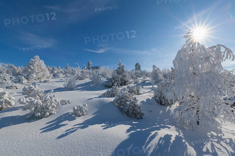Snow covered winter landscape with sun Fichtelberghaus and weather station
