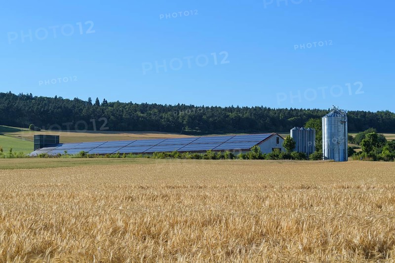 Modern animal barn with solar panels in field landscape