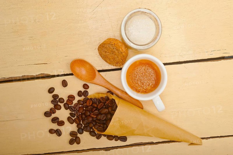 Espresso coffee and beans on a paper cone cornucopia over white background