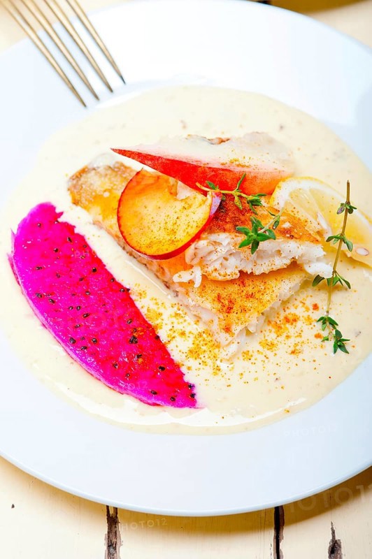 Sea bream orata fillet butter pan fried with fresh peach prune and dragonfruit slices thyme on top