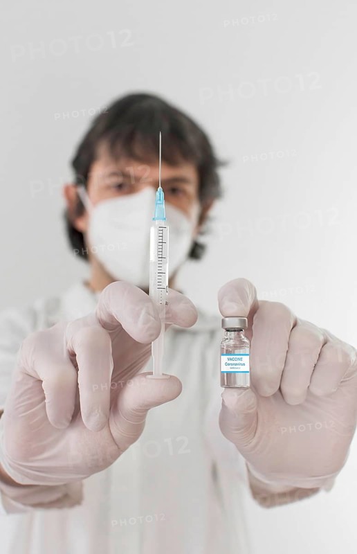 Doctor holding a vaccine bottle and syringe