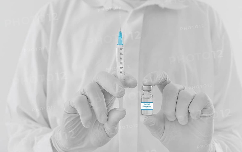Doctor hands holding a vaccine bottle and syringe