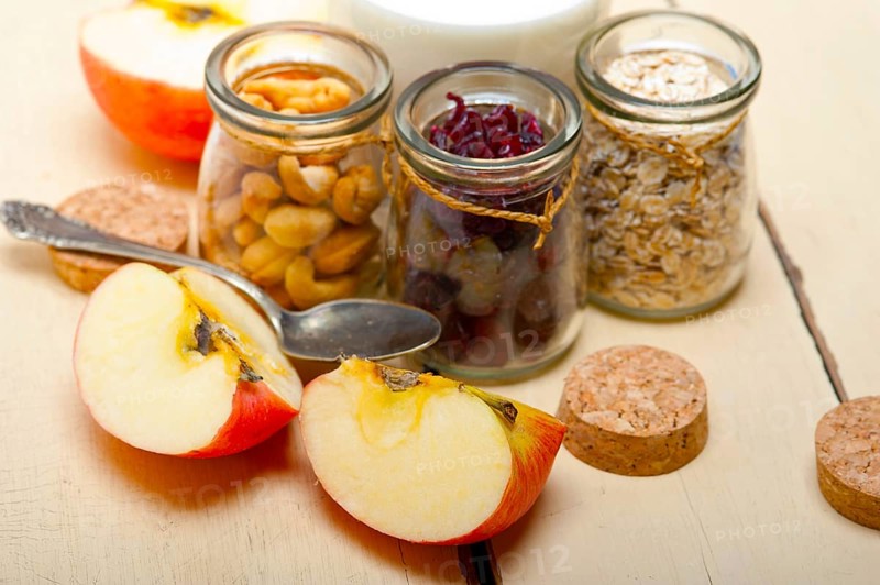 Healthy breakfast ingredients milk oat cashew nuts dried cramberry craisinns