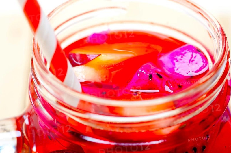 Fresh fruit punch refreshing summer drink over white rustic wood table