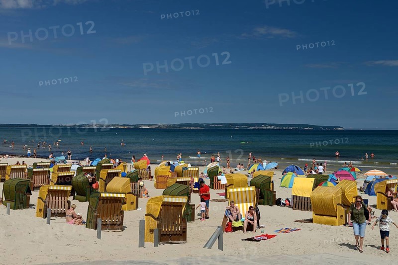 Beach chairs with holidaymakers on the beach and Baltic Sea