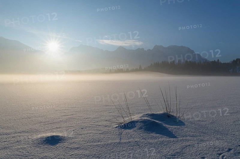 Frozen lake Barmsee with Karwendel mountainrange at sunrise in winter