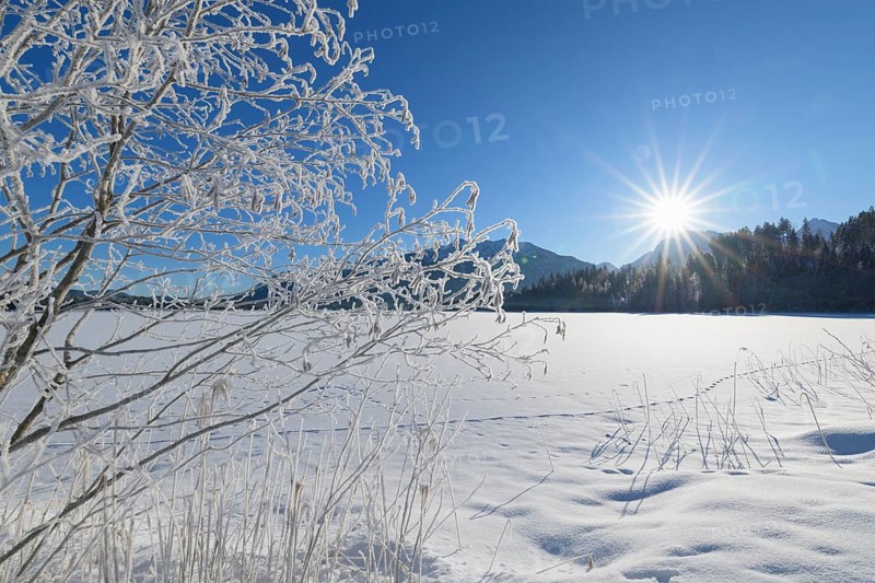 Frozen lake Barmsee with Karwendel mountainrange on morning with sun in winter