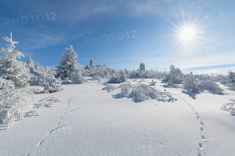 Snow covered winter landscape with sun Fichtelberghaus and weather station