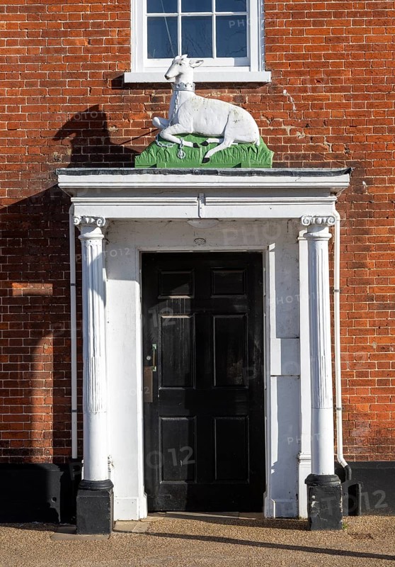 Historic sculpture of white hart deer above former entrance door to hotel