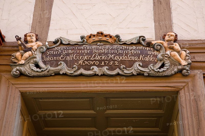 Baroque cartouche with putti above old wooden door