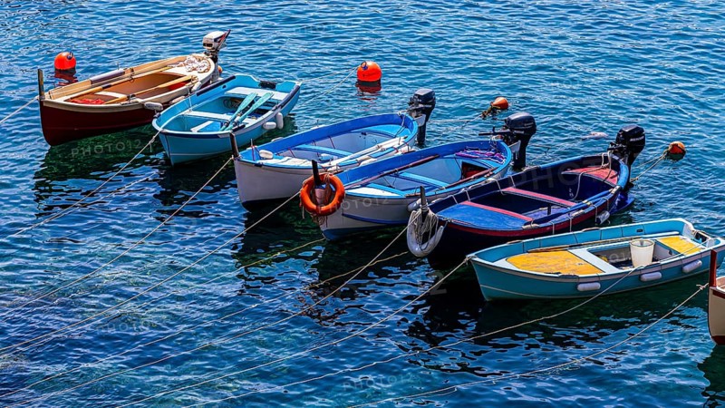 Fishing boats lie in the turquoise water in the harbour of Riomaggiore