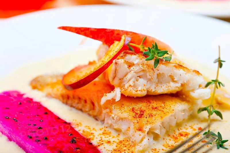 Sea bream orata fillet butter pan fried with fresh peach prune and dragonfruit slices thyme on top