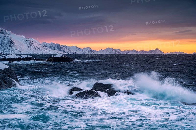 Waves and snowy coast at Hamnoy at sunrise