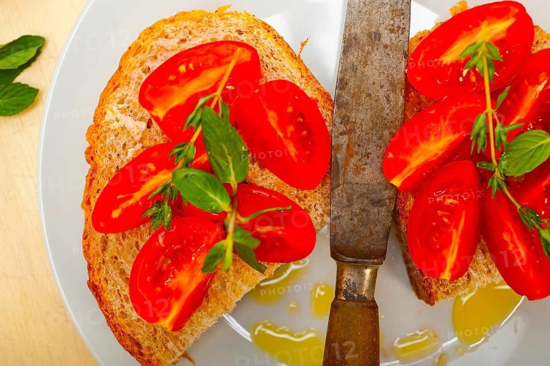 Italian tomato bruschetta with thyme and mint leaves