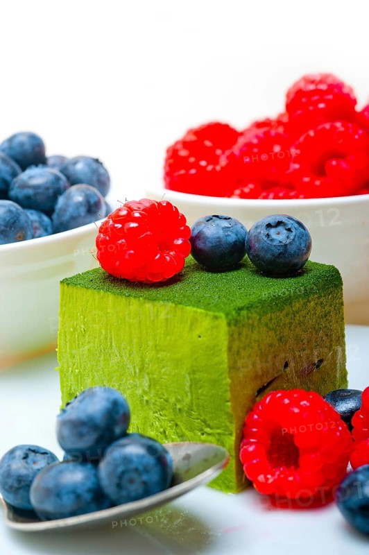 Green tea matcha mousse cake with raspberries and blueberries on top