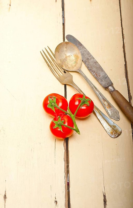 Ripe cherry tomatoes cluster over white rustic wood table