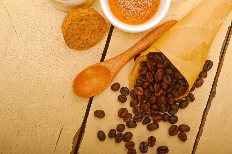 Espresso coffee and beans on a paper cone cornucopia over white background