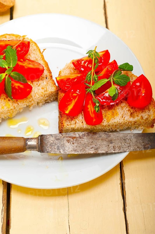 Italian tomato bruschetta with thyme and mint leaves