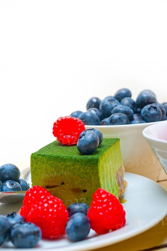 Green tea matcha mousse cake with raspberries and blueberries on top