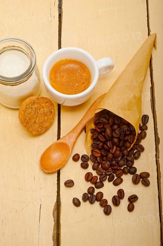 Espresso coffee and beans on a paper cone cornucopia over white background