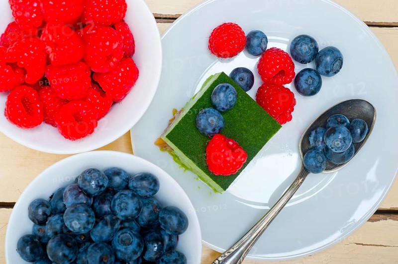Green tea matcha mousse cake with raspberries and blueberries on top