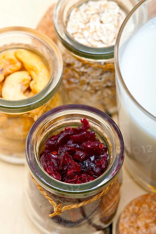 Healthy breakfast ingredients milk oat cashew nuts dried cramberry craisinns