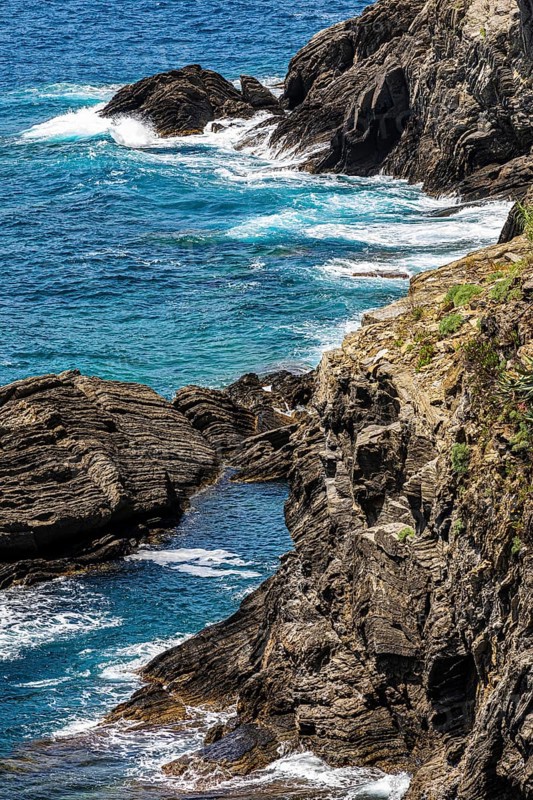 Steep cliffs washed by water on the Ligurian coast off Vernazza