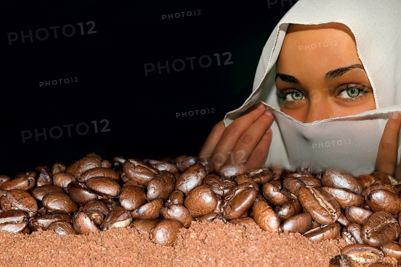 Coffee beans of the Arabica variety lie on ground coffee