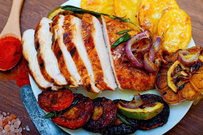Roasted grilled BBQ chicken breast with herbs and spices rustic style