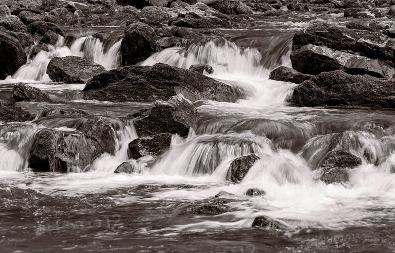 Mountain stream flows over moss-covered stones