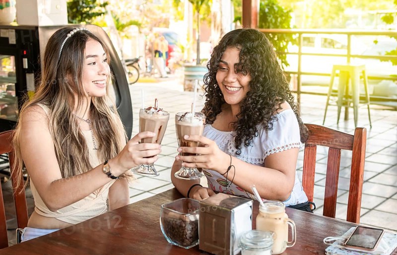 Two girls drink a milkshake